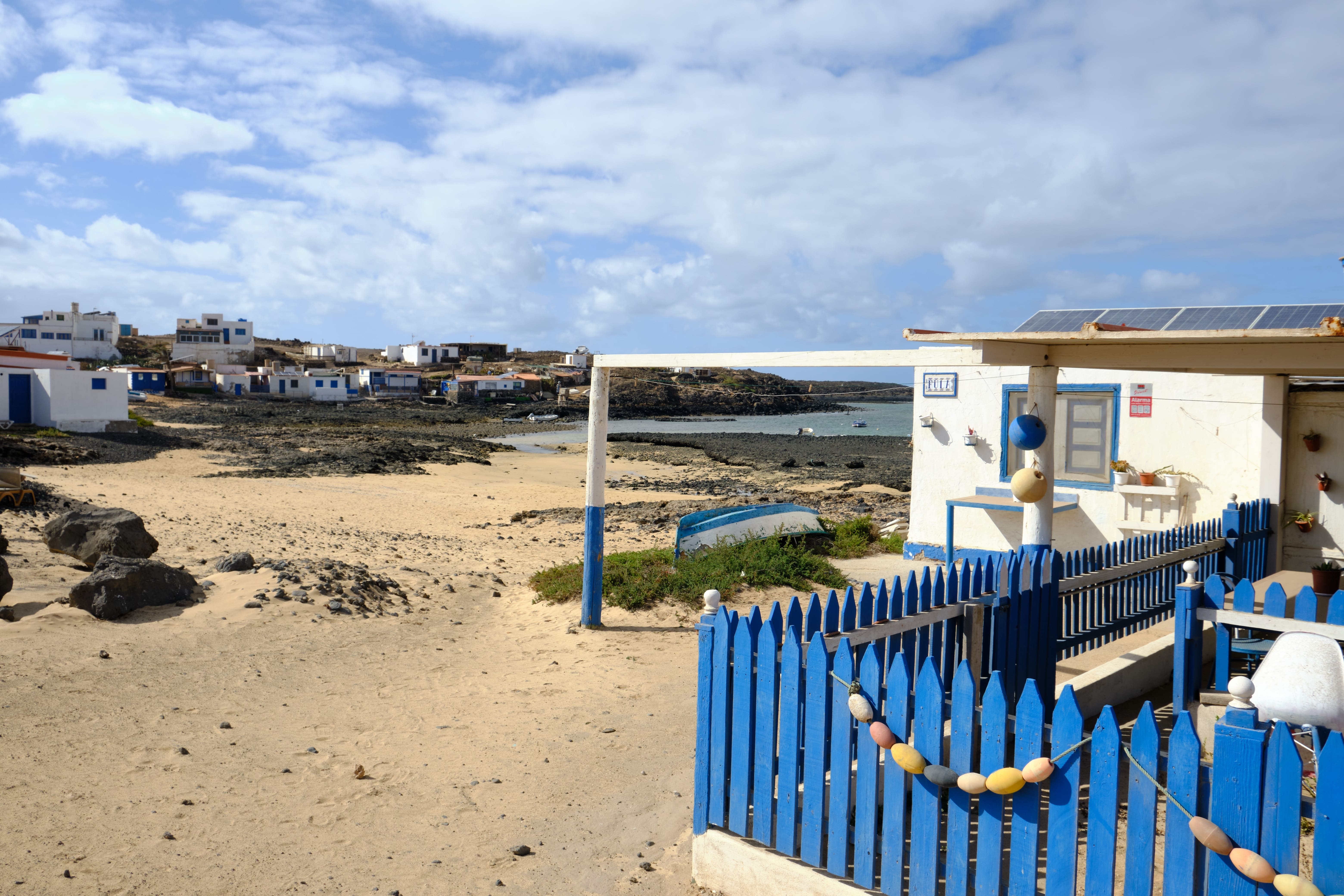 Majanicho, village de pêcheurs  à Fuerteventura avec des maisonnettes blanches et bleues le long de la côte volcanique, idéal pour une escapade tranquille.
